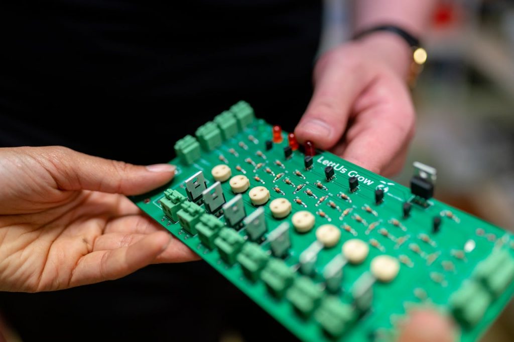 pexels-photo-3912373 Close-up of hands holding a green circuit board used for electronic projects.